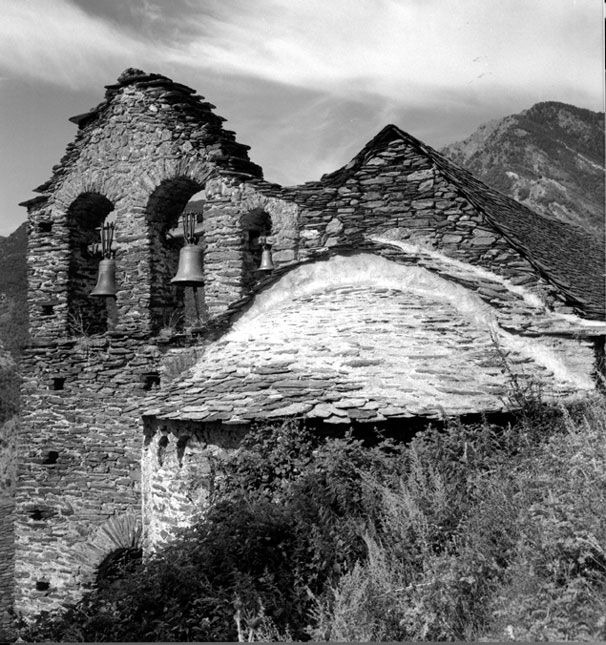 Església parroquial romànica de Sant Sebastià. Absis i campanar d'espadanya trilobat amb les corresponent campanes.