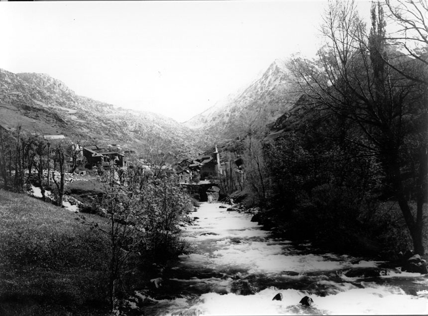 <p>Vista del poble des del riu, amb el pont al davant.</p>