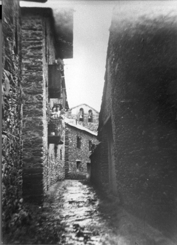 Noies al balcó de l'antiga Casa màgina amb l'església al fons.