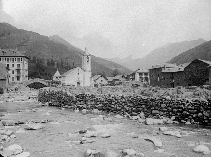 Vista general d'Isil amb els dos ponts de pedra, el comunidor i Casa Ignàsia abans de la riuada del 1937.