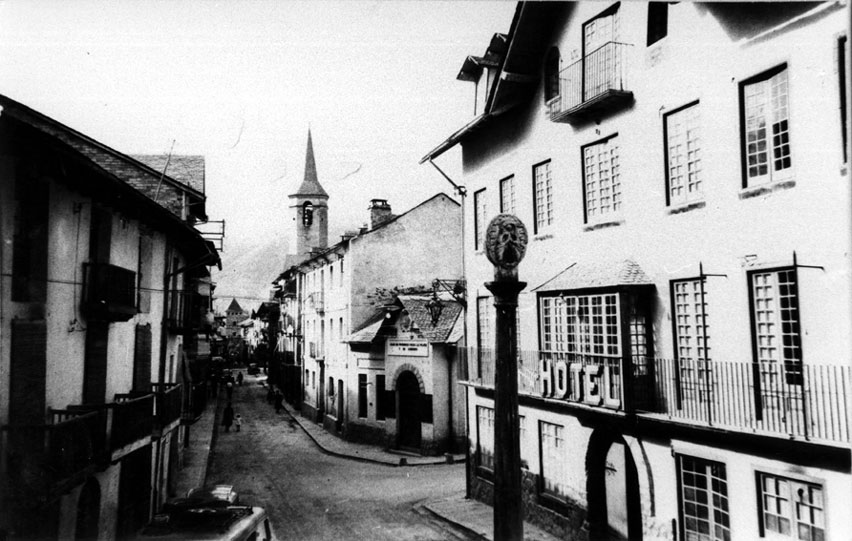 Vista del carrer Major. En primer terme, la Creu del Cap de la Vila.