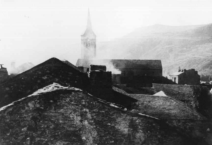 Vista de les taulades de les cases d'Esterri i del campanar de l'església parroquial de Sant Vicenç.