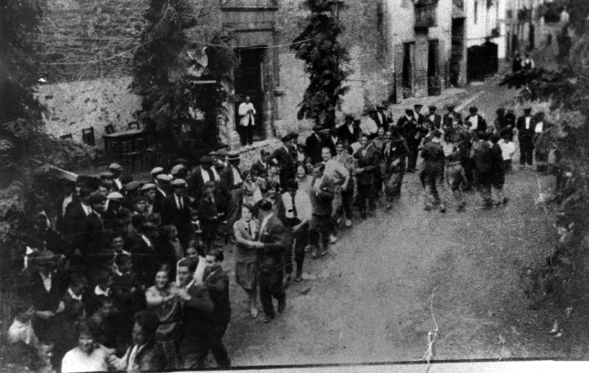 Festa major d'Esterri. Arbres per engalanar el carrer Major. Ball pla davant de l'església.