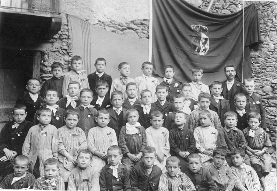 Grup escolar de nens. Al darrera de la foto hi ha el segell de l'escola: 