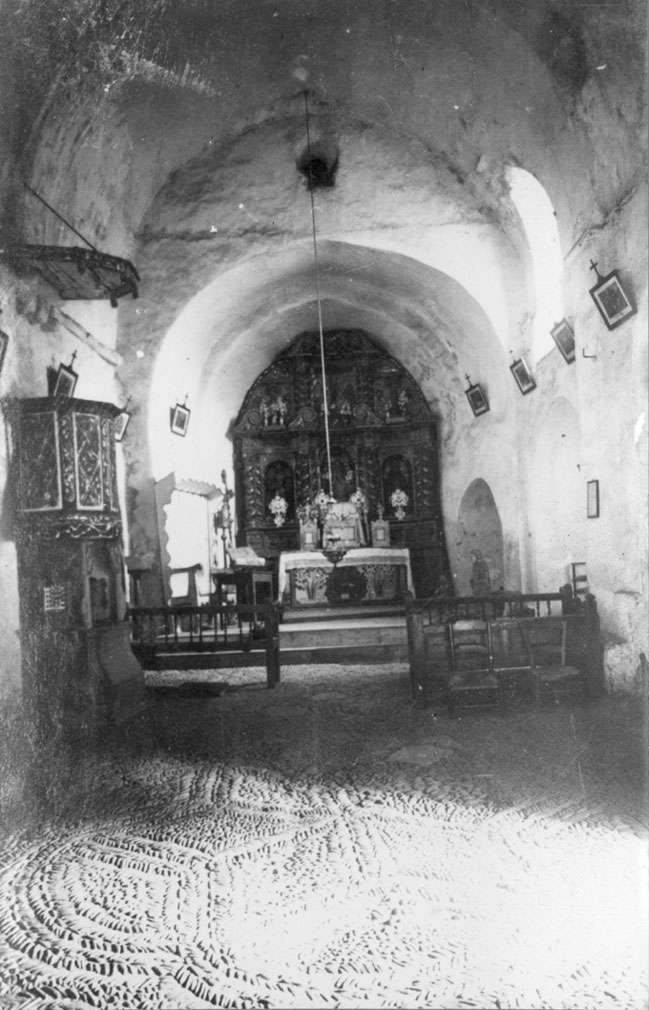 Nau central amb paviment de còdols, altar major i retaule de l'església parroquial de Sant Llorenç. 