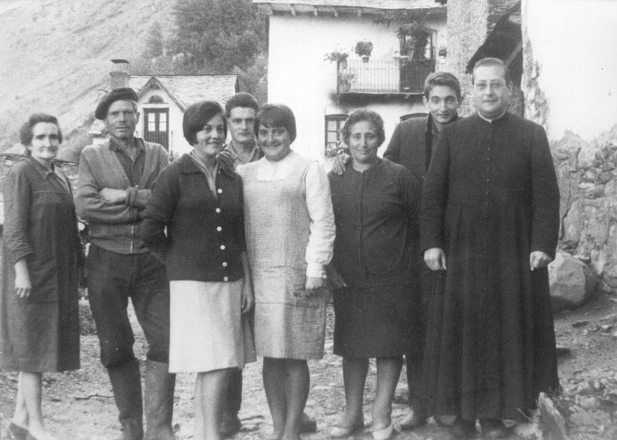 Personatges d'esq. a dreta: Dolors Ticó, Joan Constanza, Nati Constanza, Jesús Constanza, Maria Constanza (tots 5 de Casa Cinto de Burgo), Pilar Pazos de Casa Serra de Lladorre, Lluís de Casa Serra de Lladorre i mossèn Lluís Pociello. Foto feta a la plaça de Burgo, al darrera Casa Pruan.