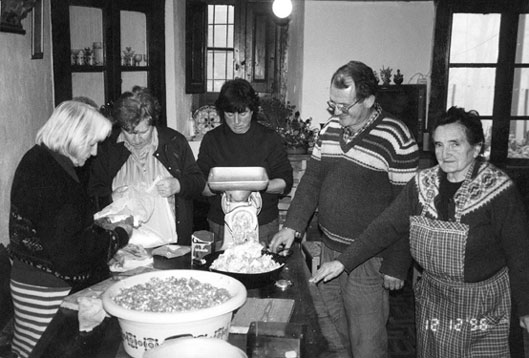 Fent el mandongo a la sala principal de Casa Cinto de Burgo. Personatges d'esq. a dreta: Aurora Picolo de Casa Llamota de Burgo, ?, Pilar Mitjana, Jesús Constanza i Dolors Ticó (la màndonguera), tots tres de Casa Cinto de Burgo.