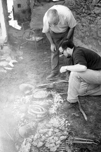 Fent una parrillada de carn pel dinar de la festa del poble. Personatges: Enric de Casa Pruan de Burgo i Casimiro, marit de la Nati Constanza de Casa Cinto de Burgo.