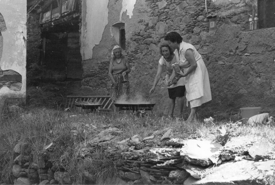 Fent una paella pel dinar de la festa del poble. Personatges d'esq. a dreta: Aurora Picolo de Casa Llamota de Burgo, Montserrat de Casa Presso de Burgo i Maria de Casa Pruan de Burgo.