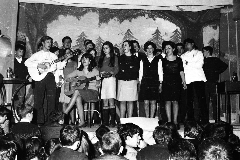 Festival de Nadal a casa Agustí. Ferran de Foro, Rafel Muniesa, Paloma de Raimundo, Cathy, Margarita de Carinyo, Lluís de Tendenou, amb la guitarra Rafel Muniesa, al darrera Josep de Gorró, Ignasieta de Marxant, Jaume de Cabirol, Trini Bardella Rella, Xelo Olave, Jaume Gallart i Pedro Sumastre.